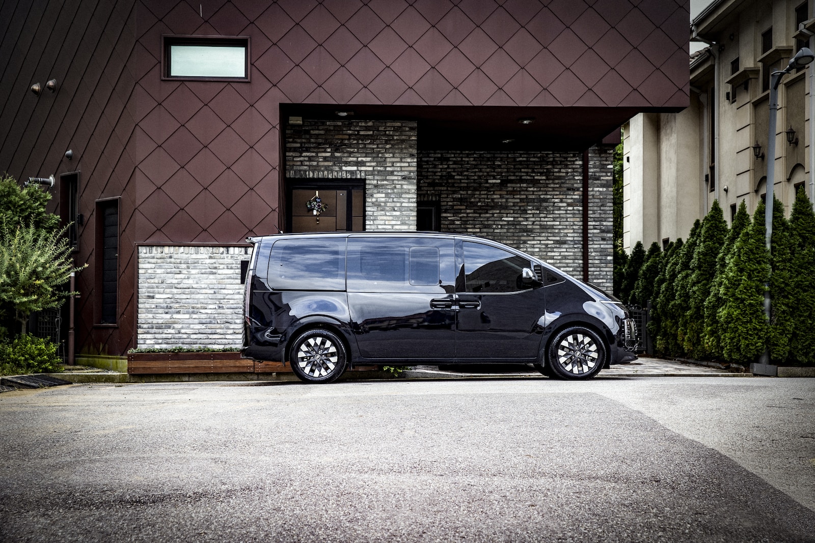 a black car parked in front of a brick building